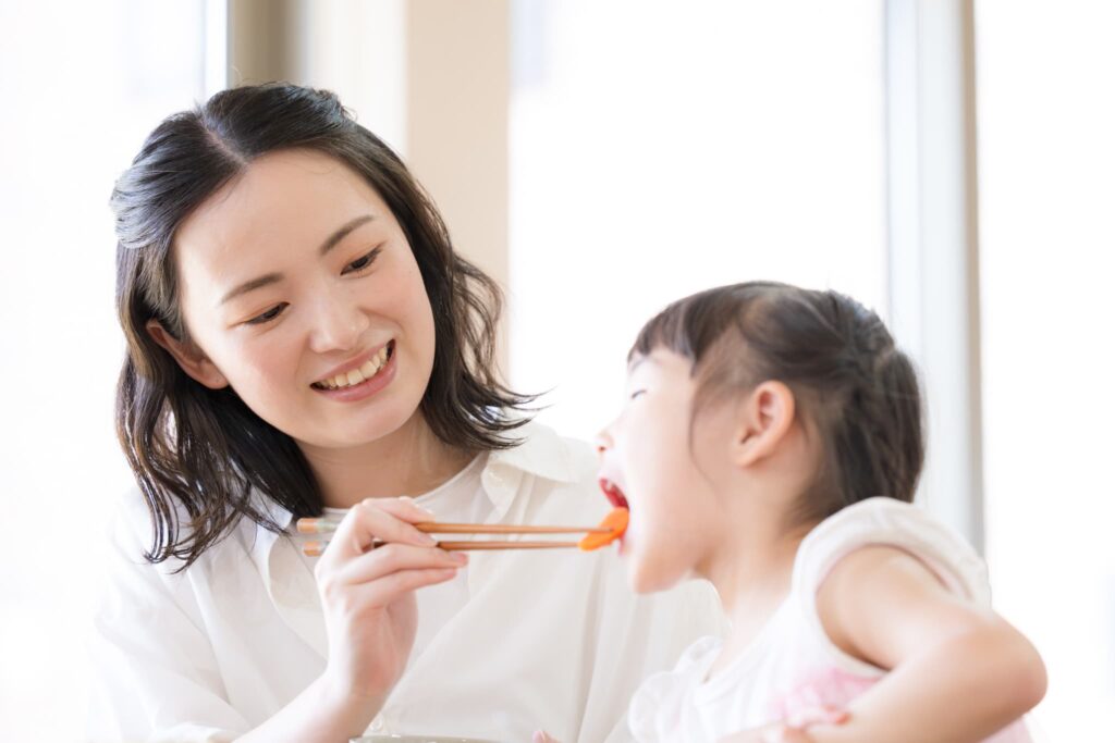 親の箸で子供に食べさせる様子