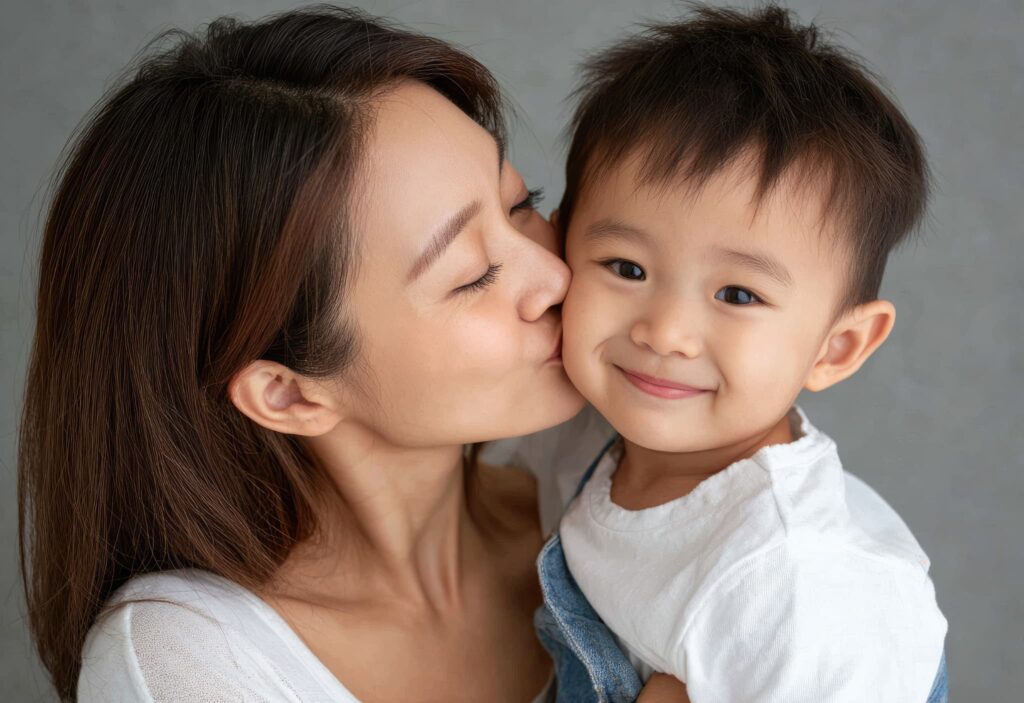 子どもの頬にキスをする母親