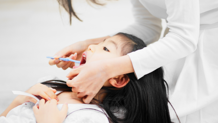 仕上げ磨きをしてもらう女の子